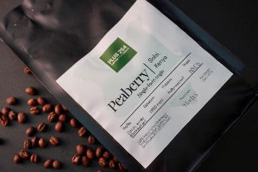 Peaberry coffee package with coffee beans on a dark surface