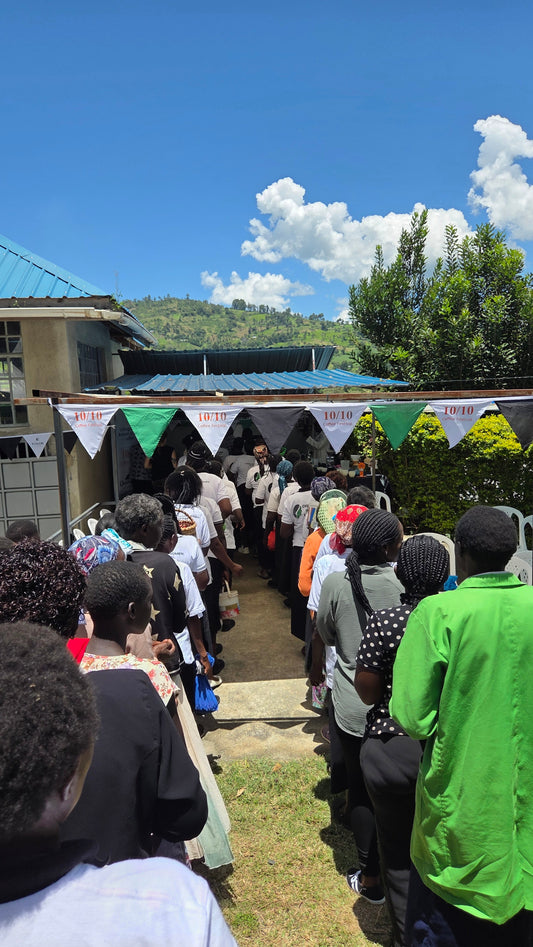 The women of Chepsangor in coffee lining up to deliver coffee into a hopper as part of Thanksgiving dat